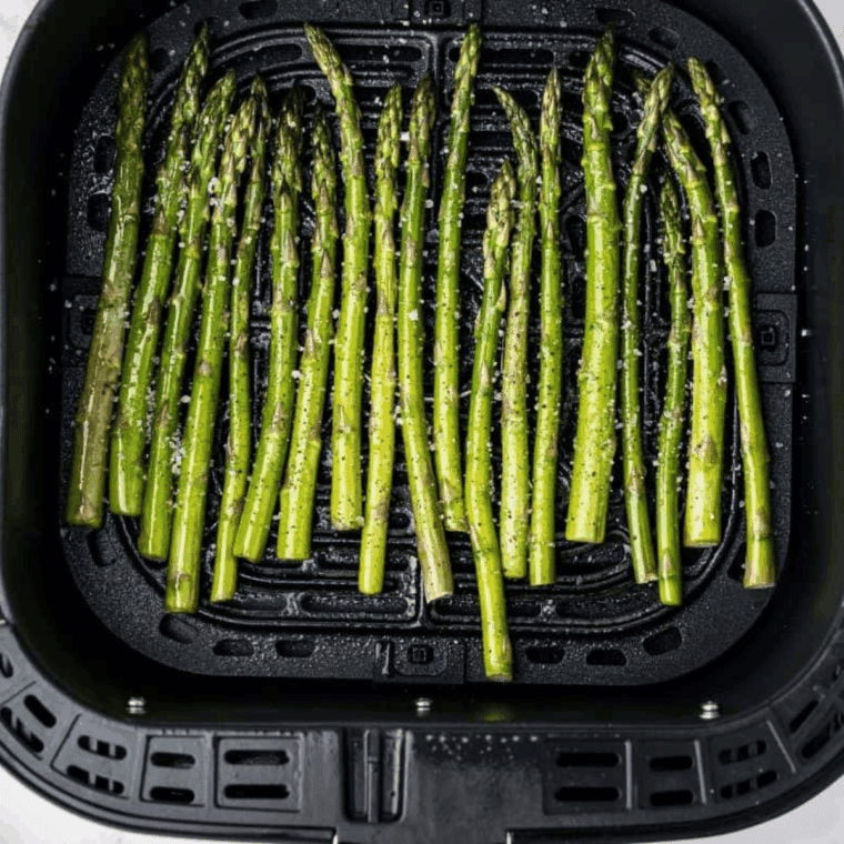 Preparing Easy Chili’s Asparagus Recipe in the air fryer basket.
