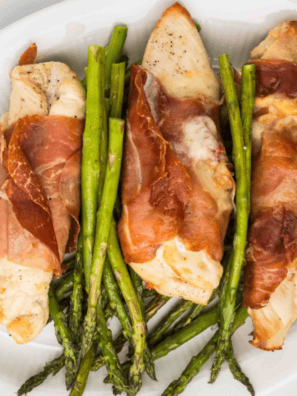Golden air fryer chicken cutlets wrapped in prosciutto and topped with sage leaves, served with lemon slices