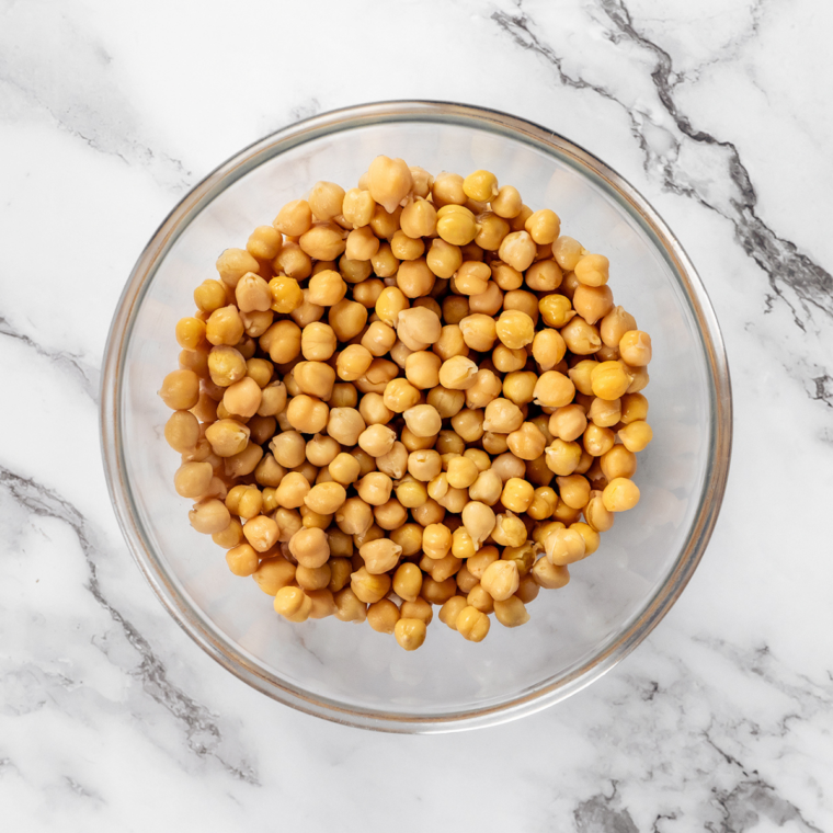 Rinsed chickpeas being patted dry with a paper towel before making air fryer taco chickpeas