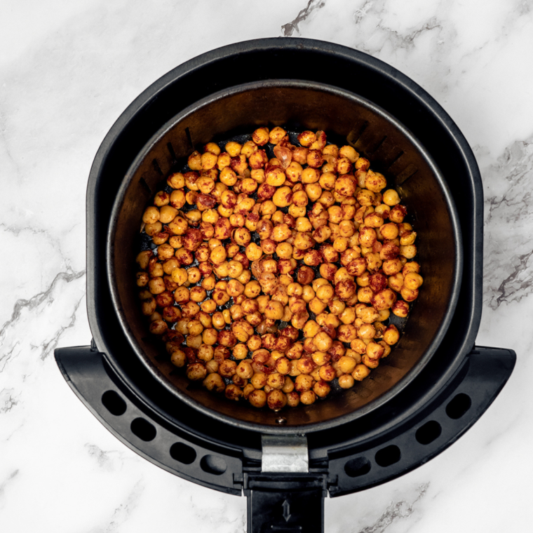 Seasoned taco chickpeas in a single layer in the air fryer basket at 390°F