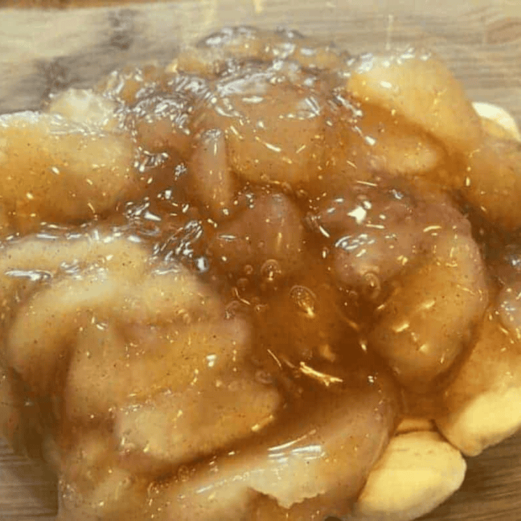 Add the apple pie filling on top of the biscuit dough, to create the gooey dessert.