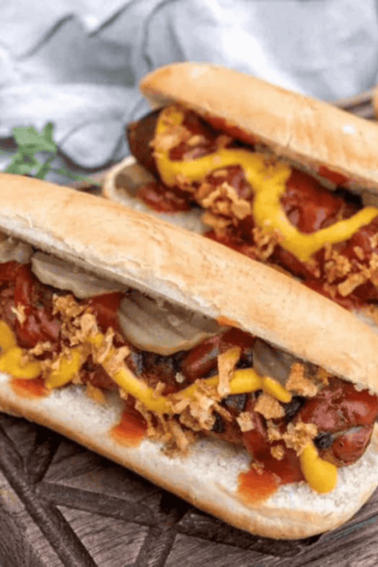 Golden crispy air fryer bacon wrapped hot dogs (danger dogs) with crunchy bacon wrapped around juicy hot dogs.