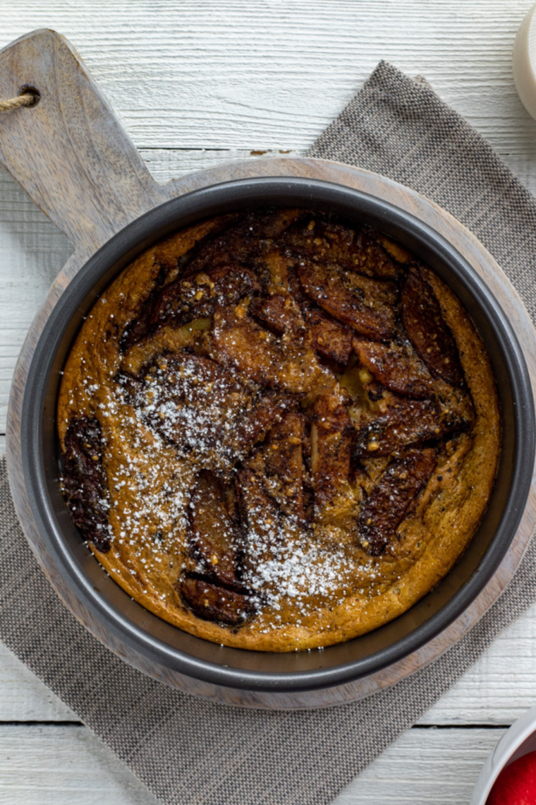 Close-up of air fryer German apple pancake dusted with powdered sugar and sliced apples