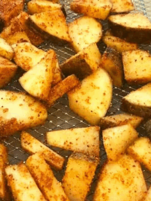 Golden air fryer potato cubes coated in glossy maple BBQ sauce, crispy outside, tender inside, served on a plate.