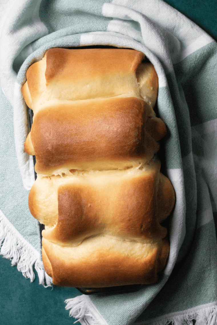 Soft and fluffy Air Fryer Milk Bread sliced and served on a wooden board with butter.