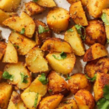 Crispy air fryer ranch potatoes in a white bowl with golden brown edges and chopped parsley