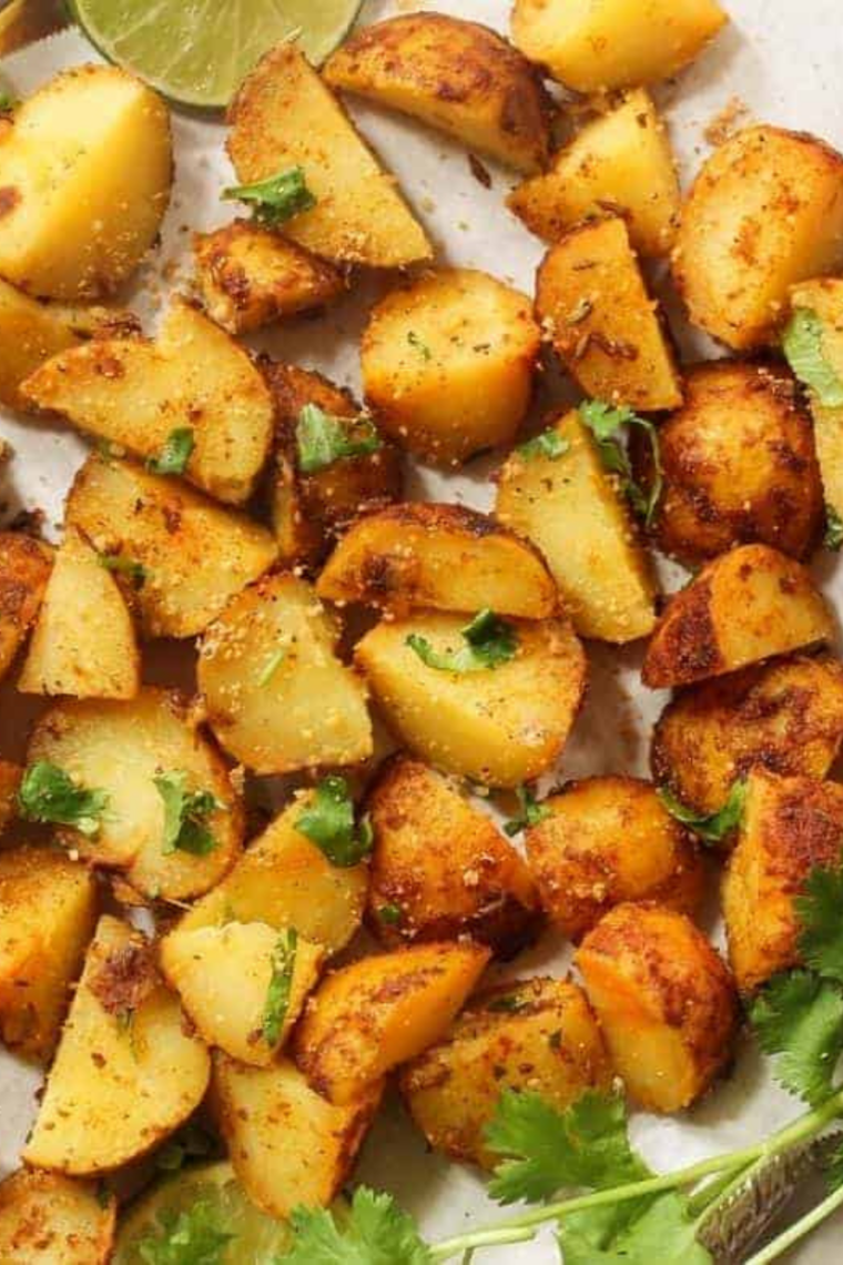 Ranch potatoes served on a plate beside a grilled chicken breast and green salad