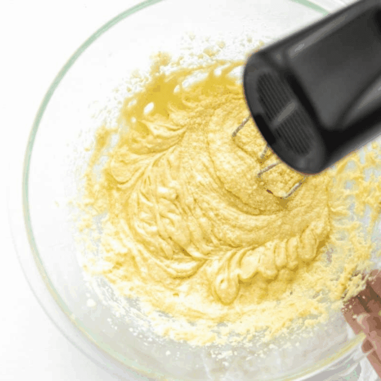Mixing eggs into butter and sugar, then gradually adding flour and buttermilk until smooth.