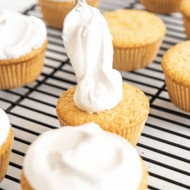 Air fryer vanilla cupcakes in paper liners, golden and fluffy, ready for frosting and serving.