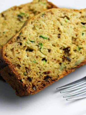 Two slices of air fryer zucchini bread on a white plate with a fork