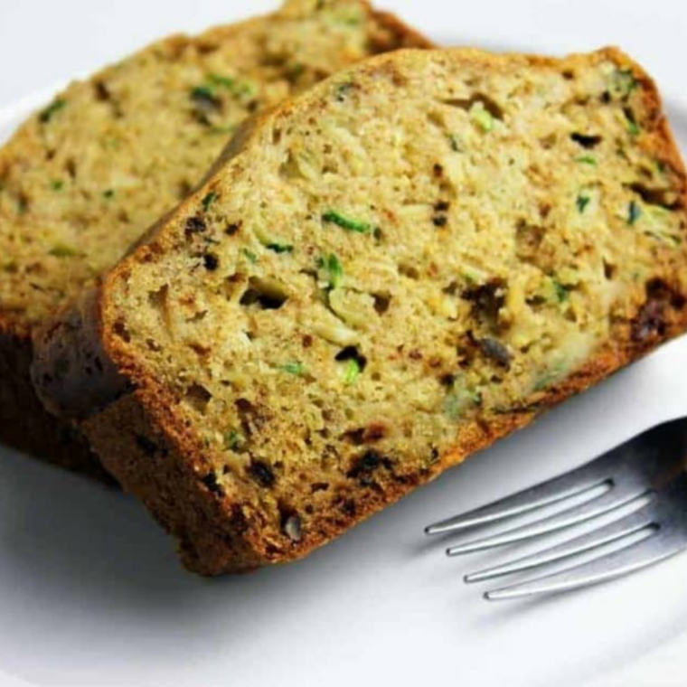 Thick slices of moist zucchini bread with visible green flecks