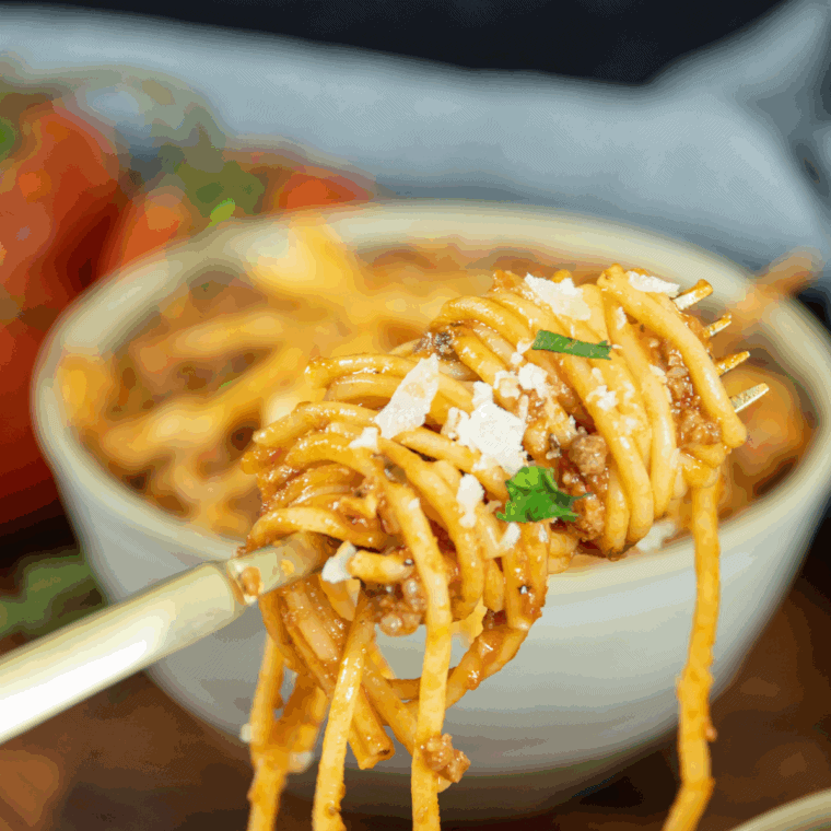 A bowl of Carrabba’s Spaghetti topped with hearty meat sauce and garnished with fresh parsley.