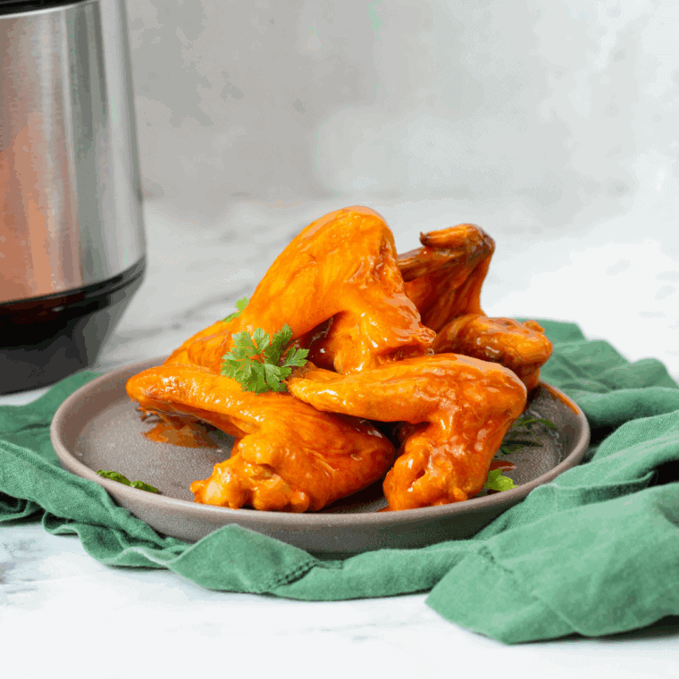 Domino’s-style hot buffalo chicken topped with melted cheese and green onions on a baking tray.