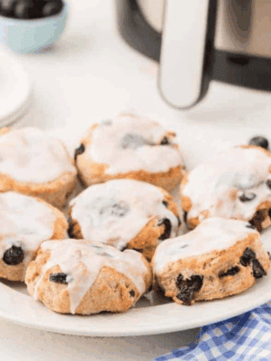 Freshly baked air fryer blueberry biscuits, golden brown with juicy blueberries peeking through.