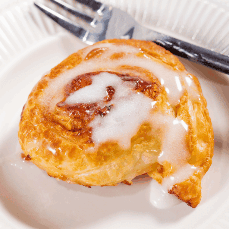 Golden brown cinnamon rolls made from frozen dough, cooked in an air fryer.