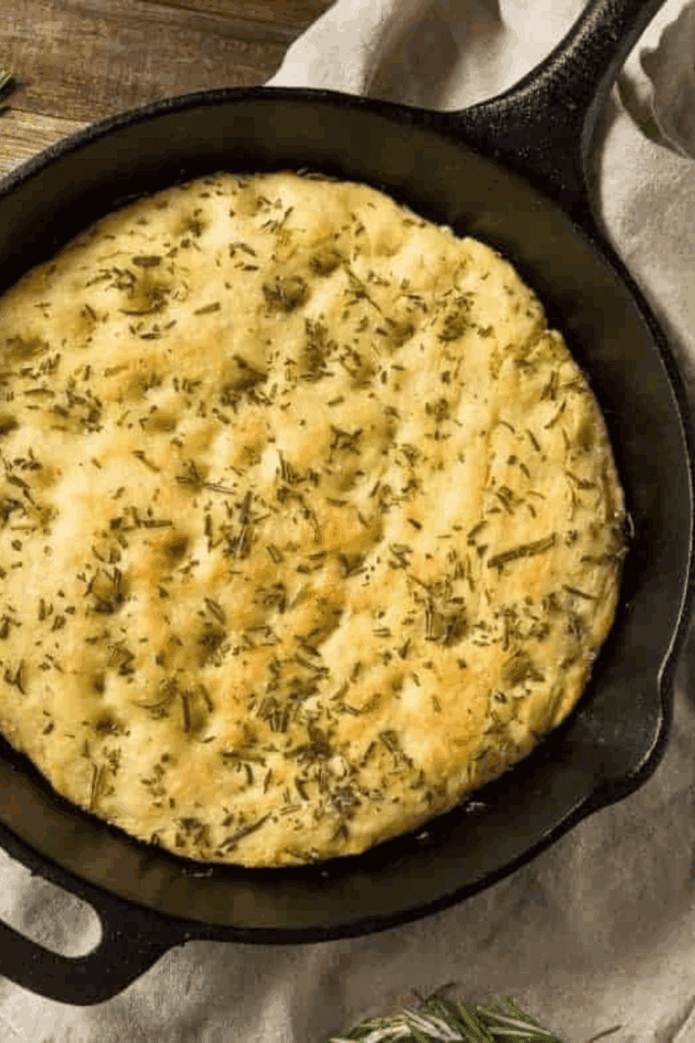 Air fryer garlic herb quick bread with golden crust, sliced and garnished with fresh herbs