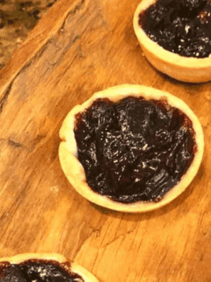 Golden air fryer jam tarts filled with bright fruit jam, served on a cooling rack.