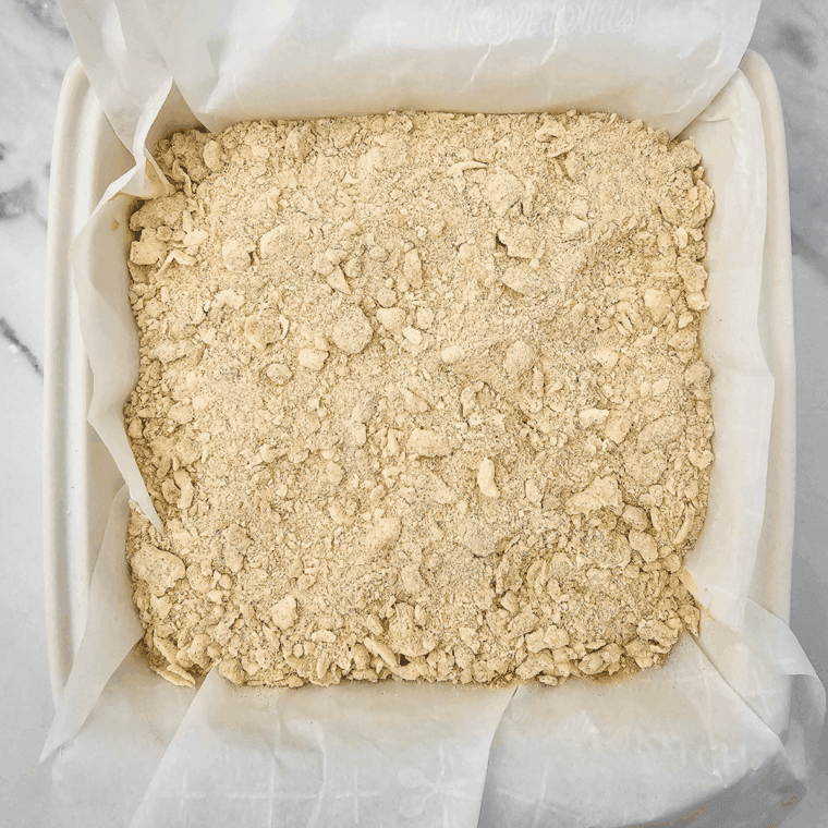 Prepare the crumb topping by combining butter, brown sugar, flour, and cinnamon in a medium bowl. Cut the butter into the mixture until crumbly and sprinkle half of it over the apple layer.