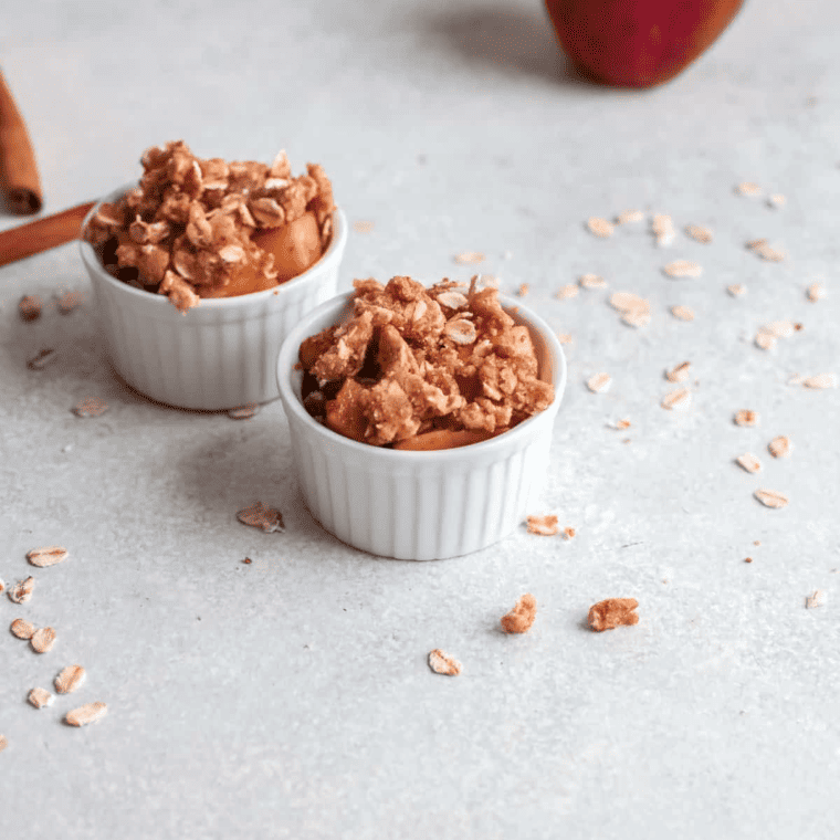 The crisp topping generously sprinkled over the layered apples in the baking dish.