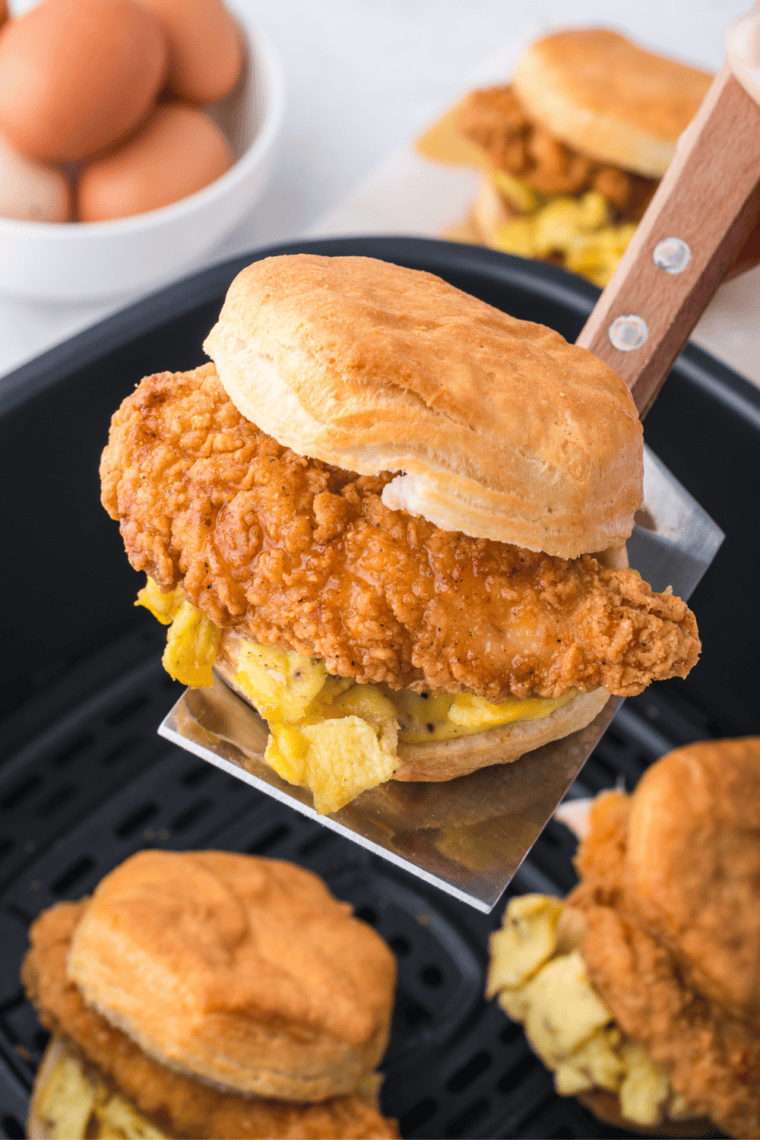 Freshly baked buttermilk biscuits in an air fryer basket, golden brown outside with soft, fluffy layers inside.