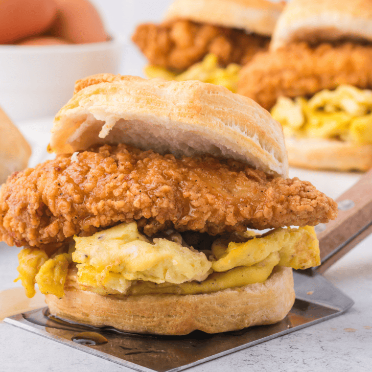 Freshly baked homemade buttermilk biscuits in an air fryer basket, showing golden tops and soft flaky layers inside.