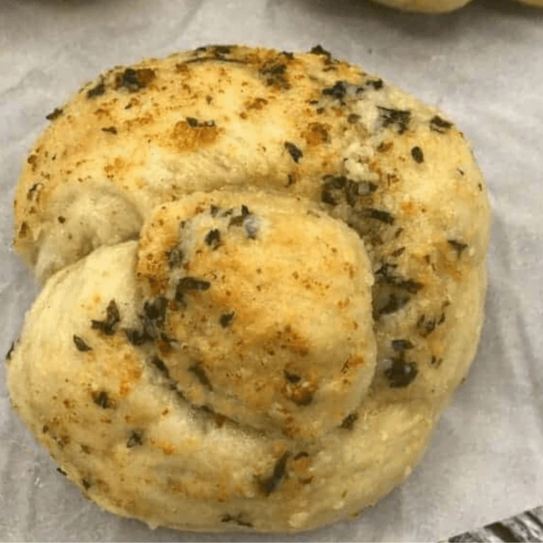 Golden Air Fryer Garlic Knots brushed with melted garlic butter and parsley on a serving plate