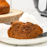 Frosted air fryer pumpkin cake on a white plate ready to serve