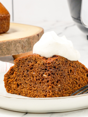 Frosted air fryer pumpkin cake on a white plate ready to serve