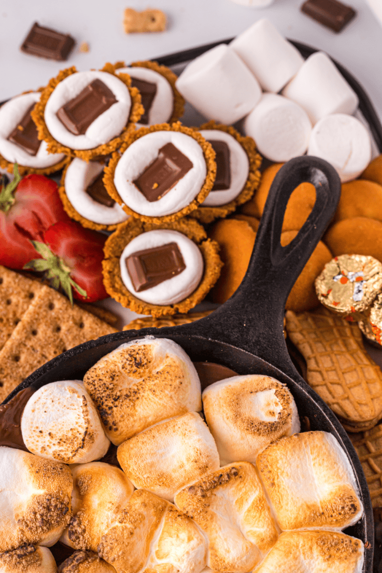 Air fryer s’mores cookie cups with melted chocolate and golden toasted marshmallows on top.