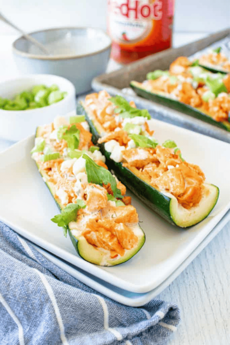 Golden-brown Air Fryer Zucchini Boats arranged on a white plate, showcasing a colorful vegetable filling.