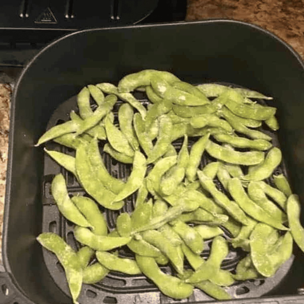 Place frozen edamame in the air fryer basket.