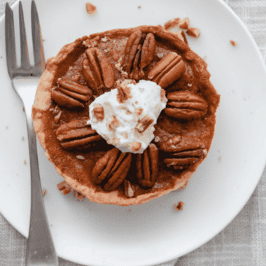 Air fryer pecan pie on a dessert plate with one slice removed