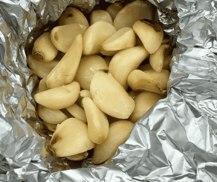 overhead closeup: roasted garlic in air fryer in a foil packet
