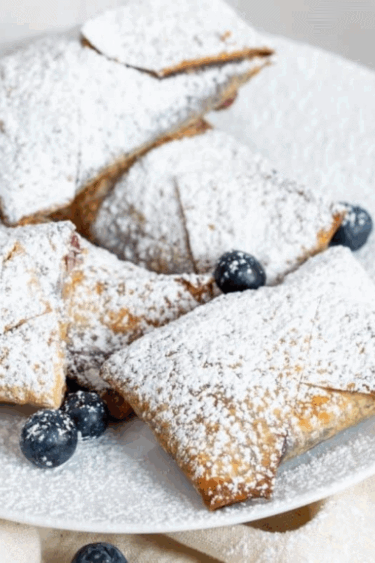 Close up of cheesecake egg rolls with crispy wrappers and creamy filling inside.