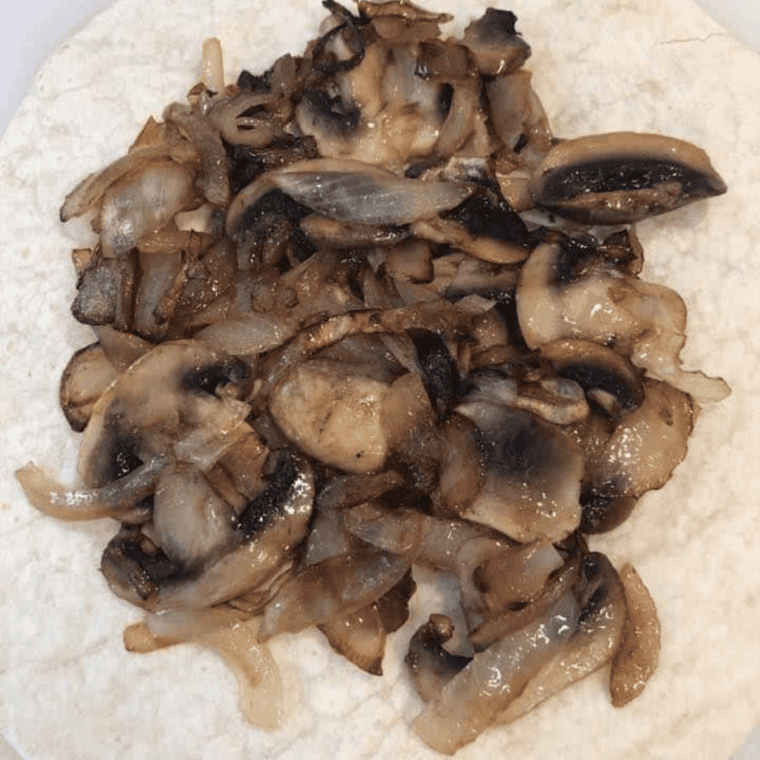 Sauteeing mushrooms and onions in olive oil until browned.