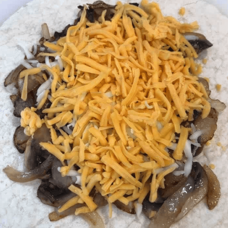 Sprinkling shredded cheese on mushrooms and onions, then layering.
