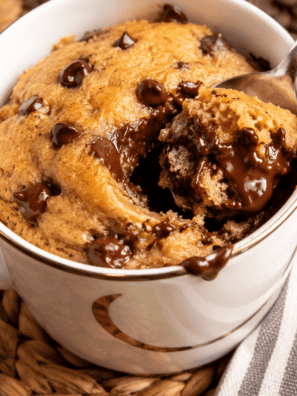 Air fryer chocolate chip mug cake baking in the basket until golden
