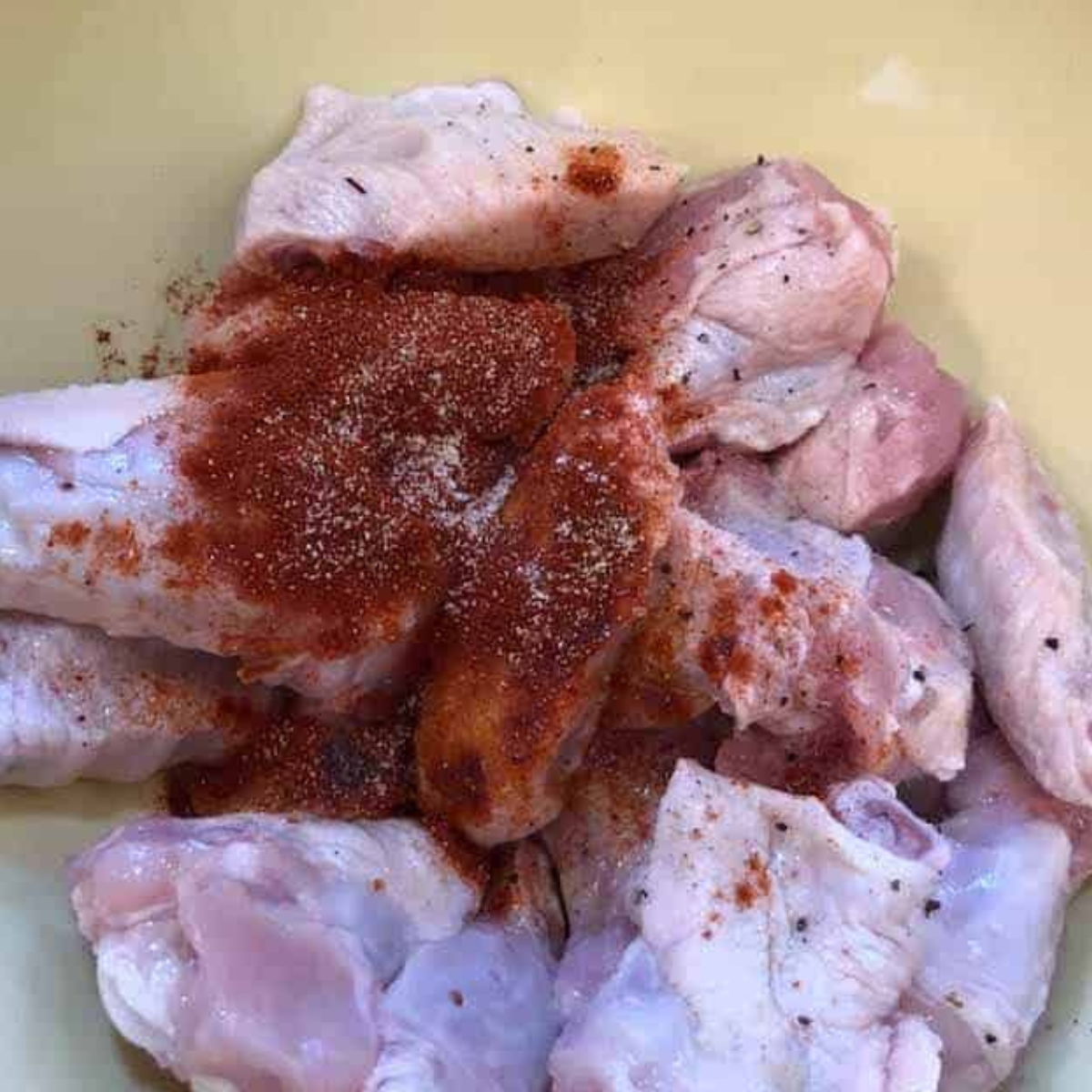 Adding salt, pepper, garlic powder, and smoked paprika to the wings