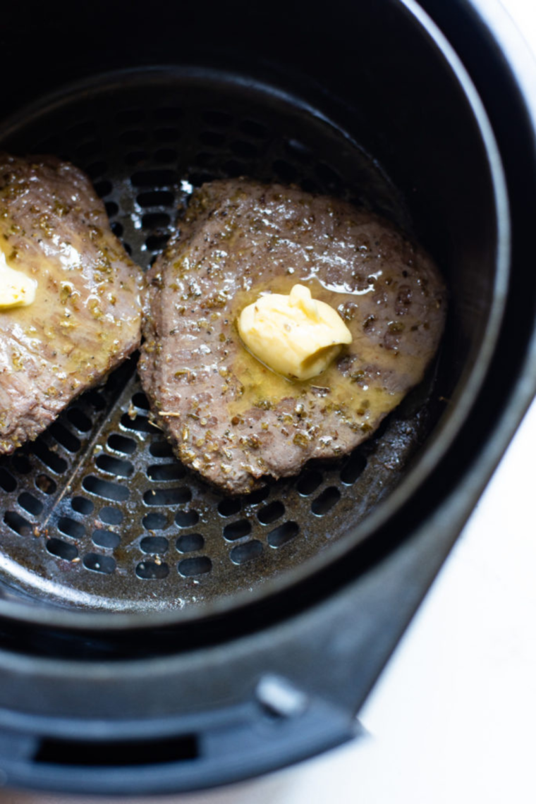 Slicing juicy air fried steak on a wooden cutting board for a steak salad.