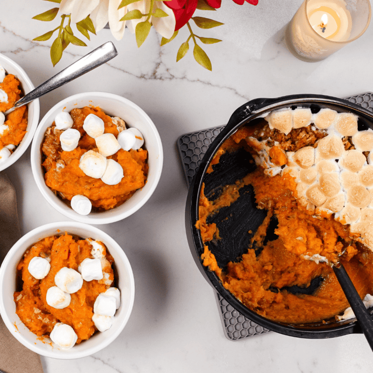 Creamy sweet potato casserole with a crispy pecan topping in a white baking dish