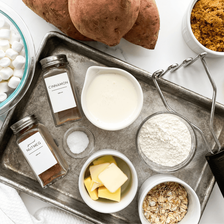 Sweet potatoes, butter, brown sugar, pecans, cinnamon, and mini marshmallows on a kitchen counter