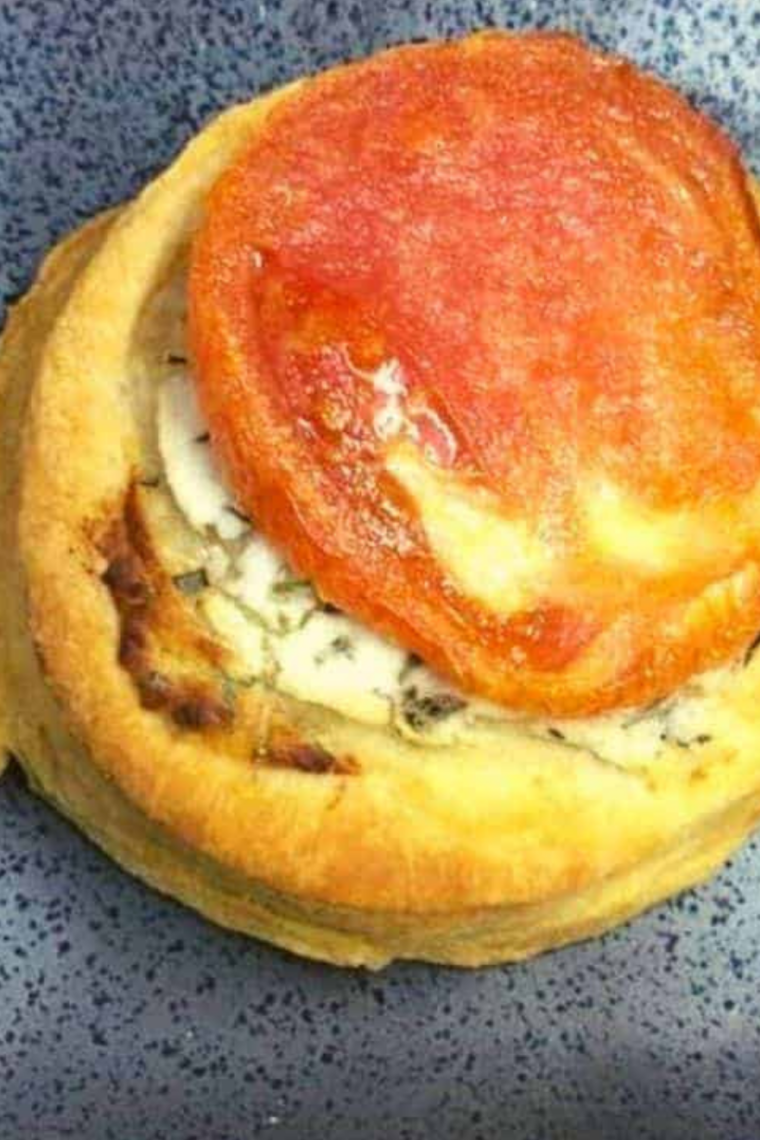 Close-up of air fryer tomato tarts with bubbling goat cheese and herbs