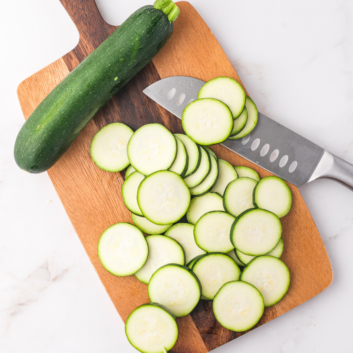 Sliced zucchini laid out on foil, ready to be seasoned.