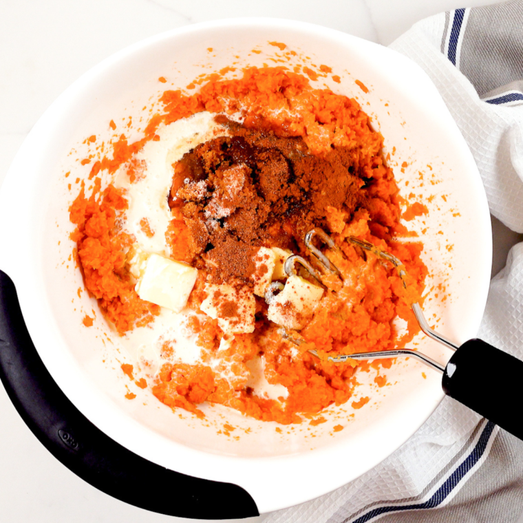 Draining and mashing the sweet potatoes, then folding in butter, cream, and spices.