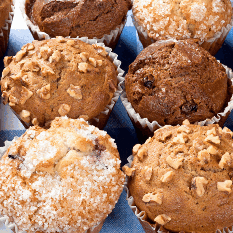 Assorted air fryer muffin pans including silicone and metal options, displayed on a kitchen counter.