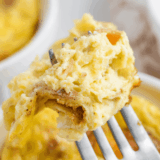 Fluffy air fryer mug omelet with melted cheddar cheese and scallions in a white ramekin