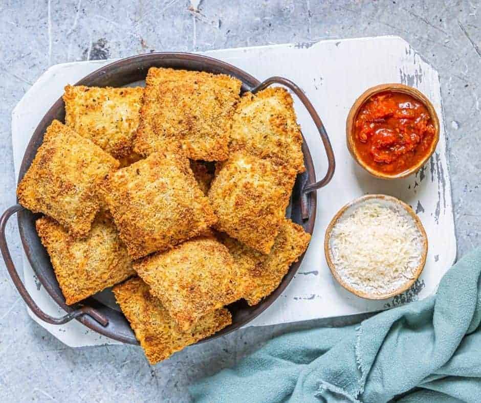 "Crispy Air Fryer Olive Garden Toasted Ravioli on a plate with marinara sauce for dipping, a delicious appetizer or snack."