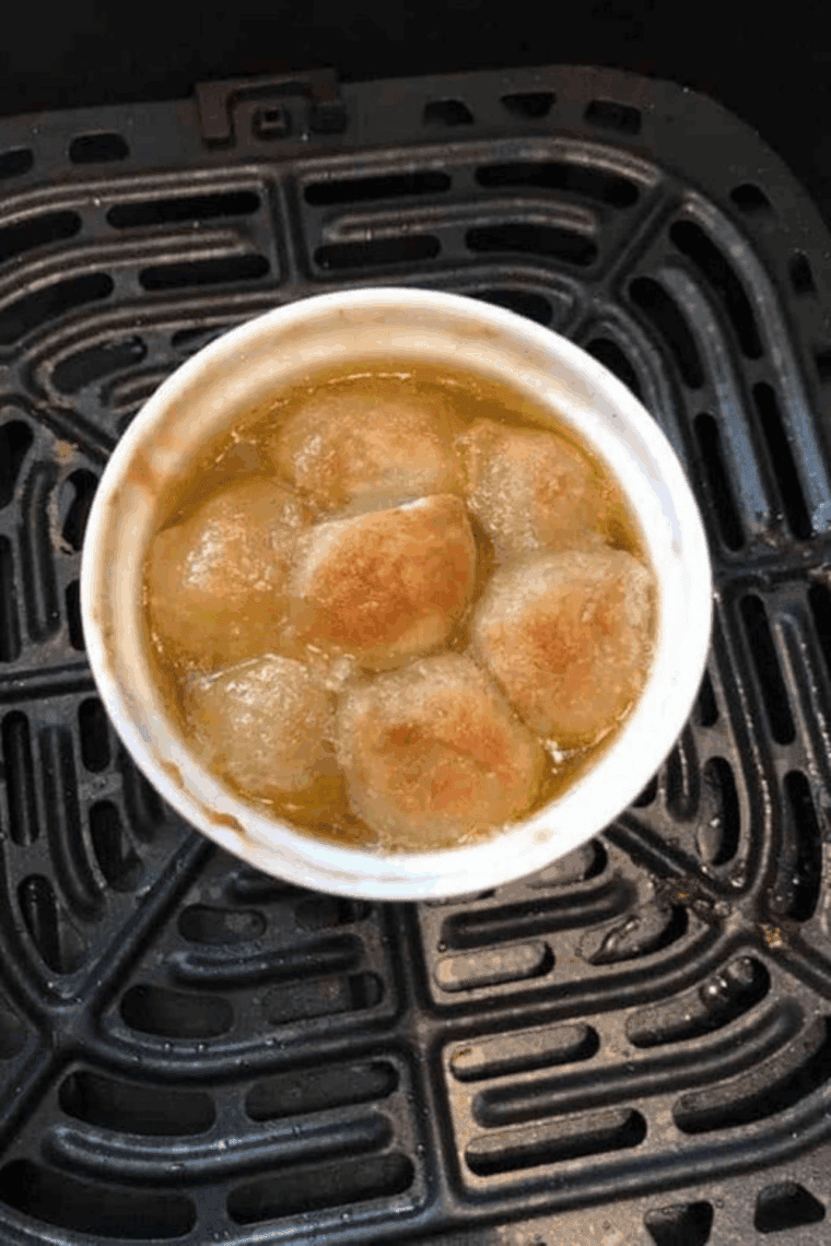 Single serve monkey bread in an air fryer basket, golden and gooey