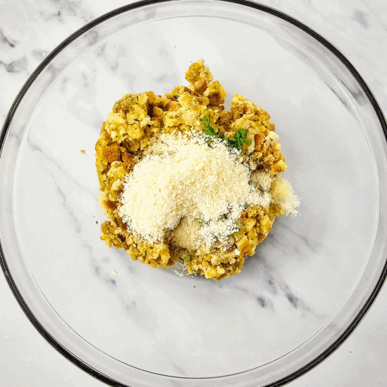 Prepared stuffing mixed with Parmesan cheese, parsley, and salt in a bowl.