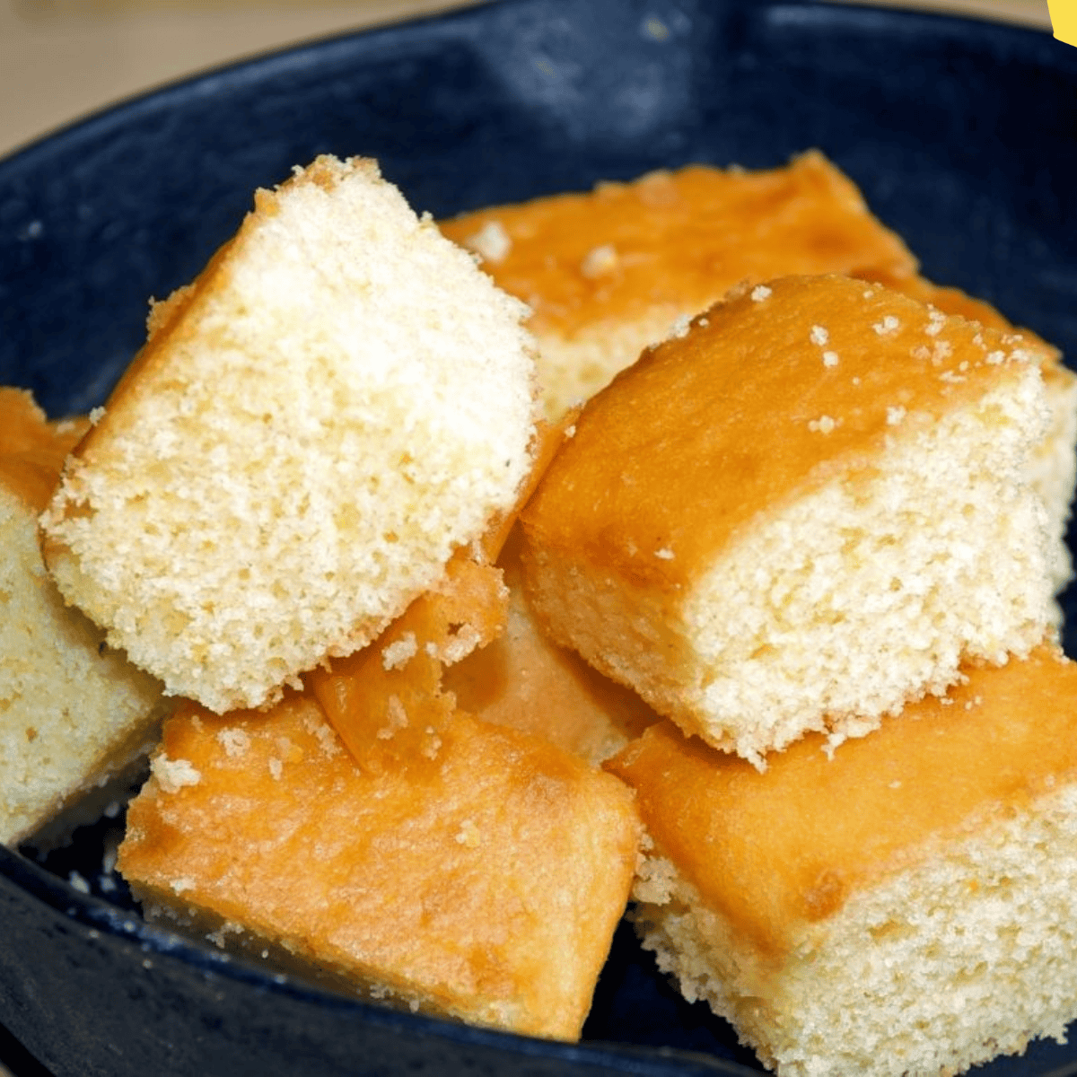 Thick, golden slices of homemade Boston Market-style cornbread stacked on a white plate.